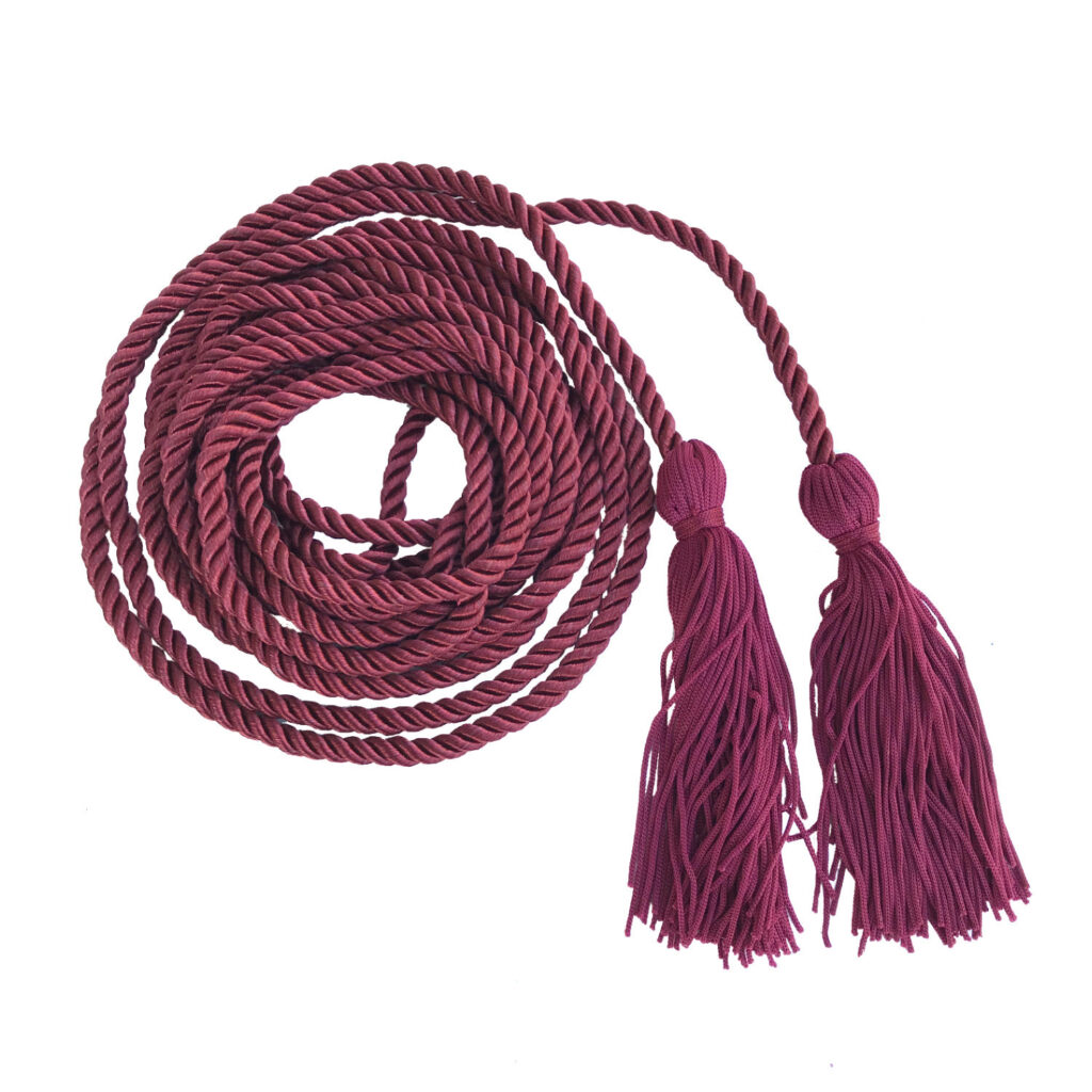 A red braided cord coiled in a pile with two tassels on each end.
